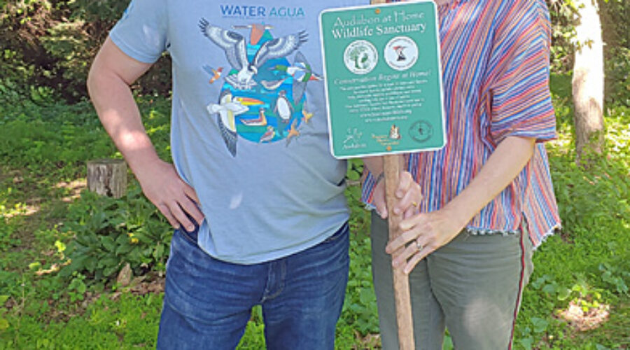 Scott and Becky Harris with wildlife sanctuary sign