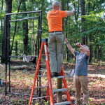 Volunteers pull wire for third fence