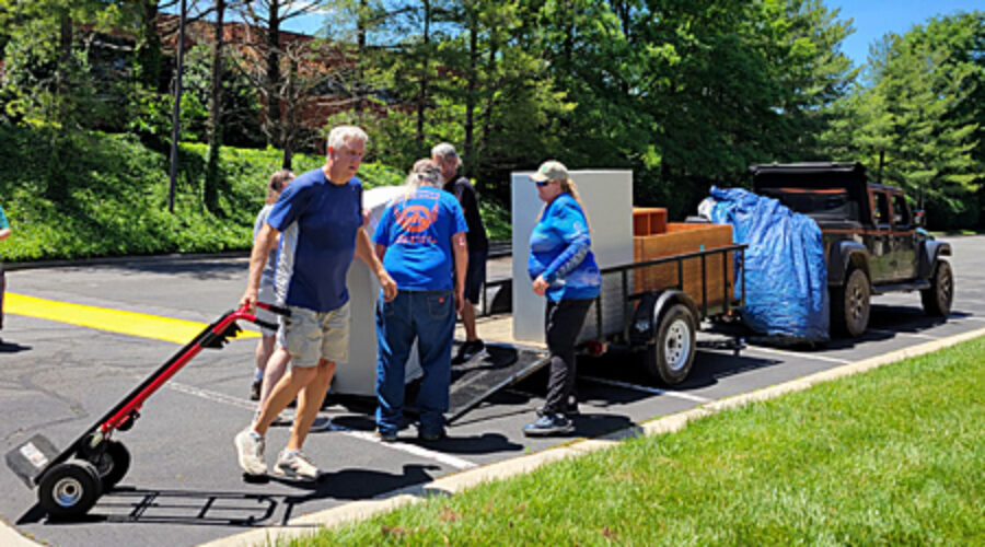 Volunteers load furniture onto trailer.