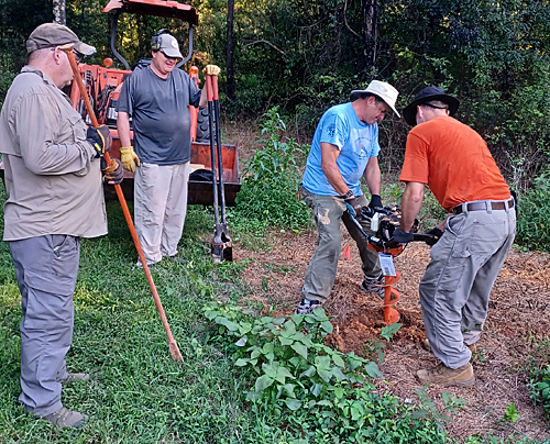 Volunteers digging hole for sign
